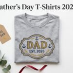 fathers day t-shirts 2026 featuring a personalized Dad Est 2026 vintage badge design on a grey shirt by PrintifyGifts
