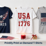Three Printify Print on Demand T-Shirts for men displayed on white wall featuring JAMES eagle design, USA 1776 typography, and FREEDOM American flag graphic with patriotic props on shelf below